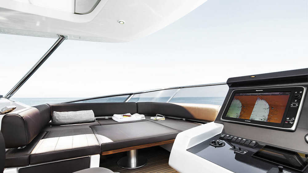 Seating area next to helm station on fly convertible in sunbathing area