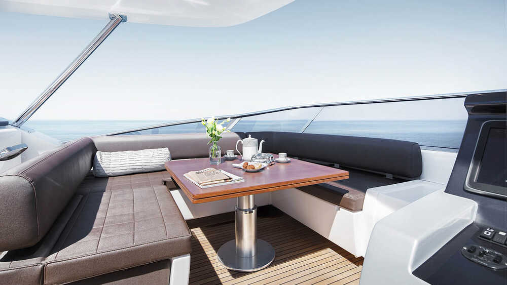 Seating area next to helm station on fly convertible in sunbathing area